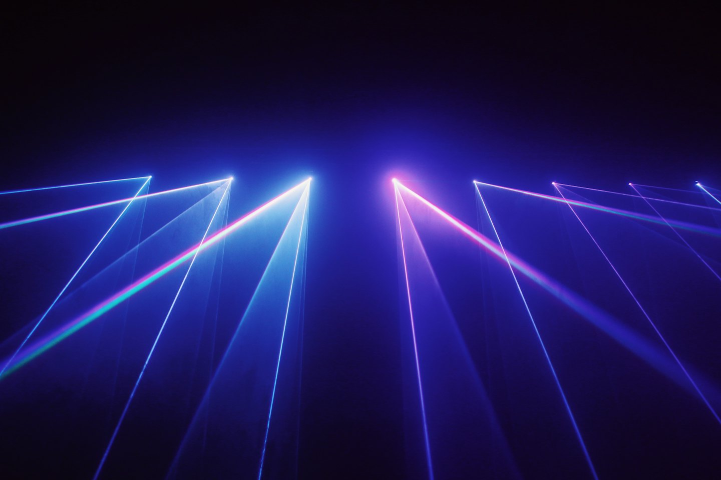 Helle Laserstrahlen erzeugen eine lebendige Lichtshow in der Dunkelheit.