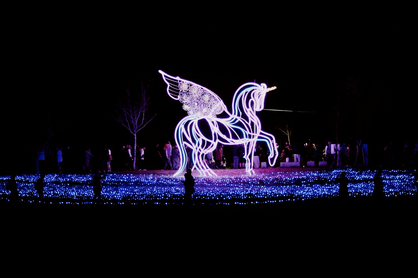 Eine leuchtende Einhorn-Skulptur steht über einem Feld aus funkelnden Lichtern.